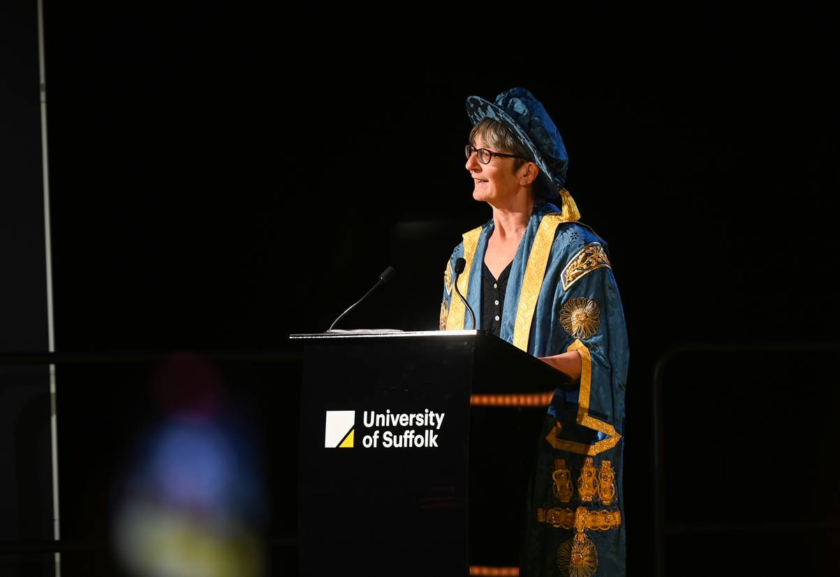 Dr Helen Pankhurst dressed in Chancellor's robes speaking at a 2024 graduation ceremony. She is standing behind a lectern and addressing an audience