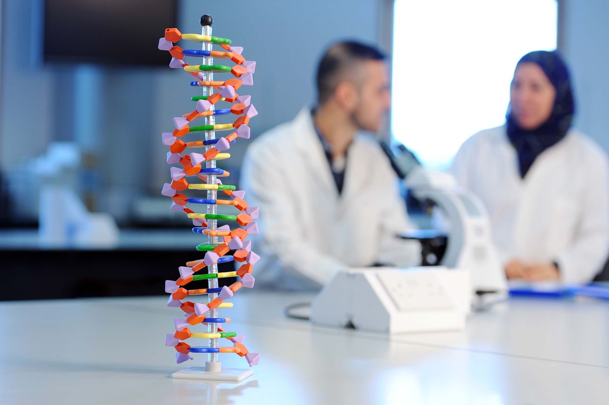 DNA helix model and students in a laboratory