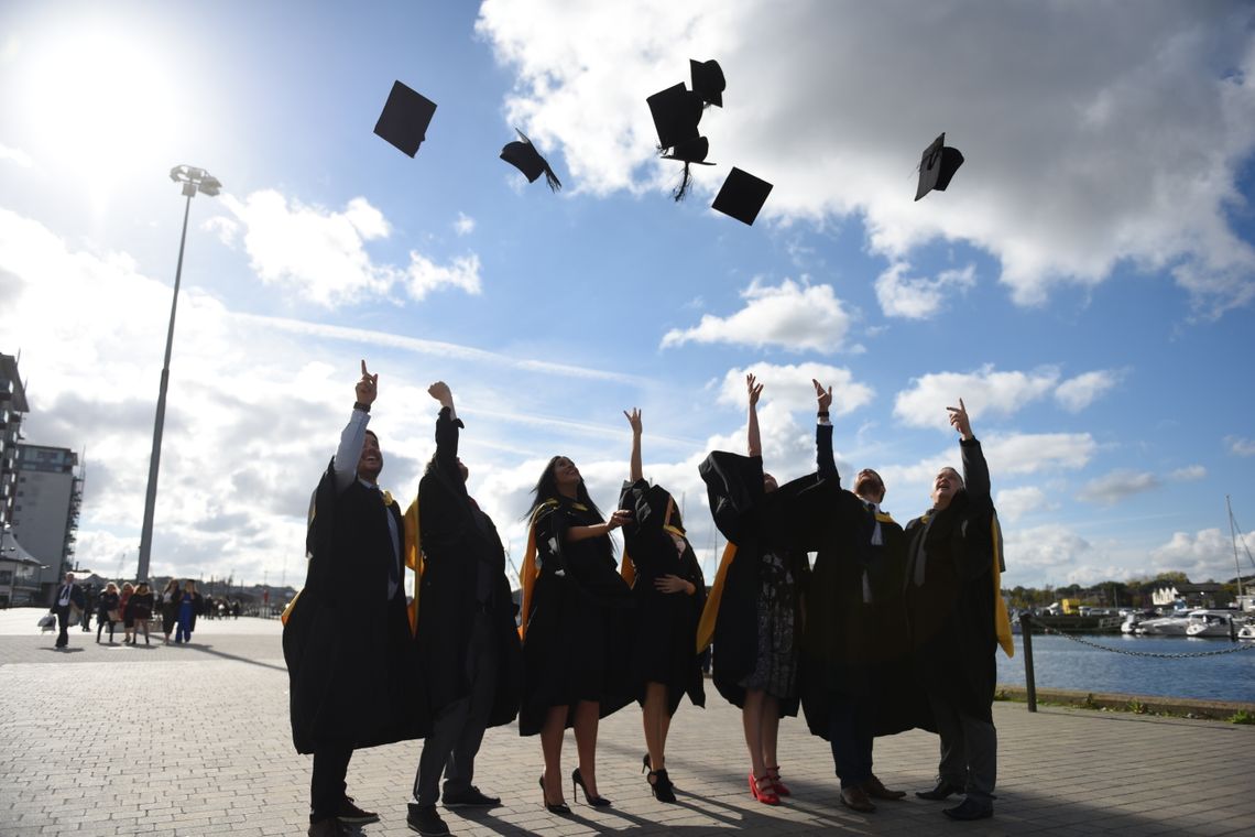 A group of students throwing their mortar boards in the air