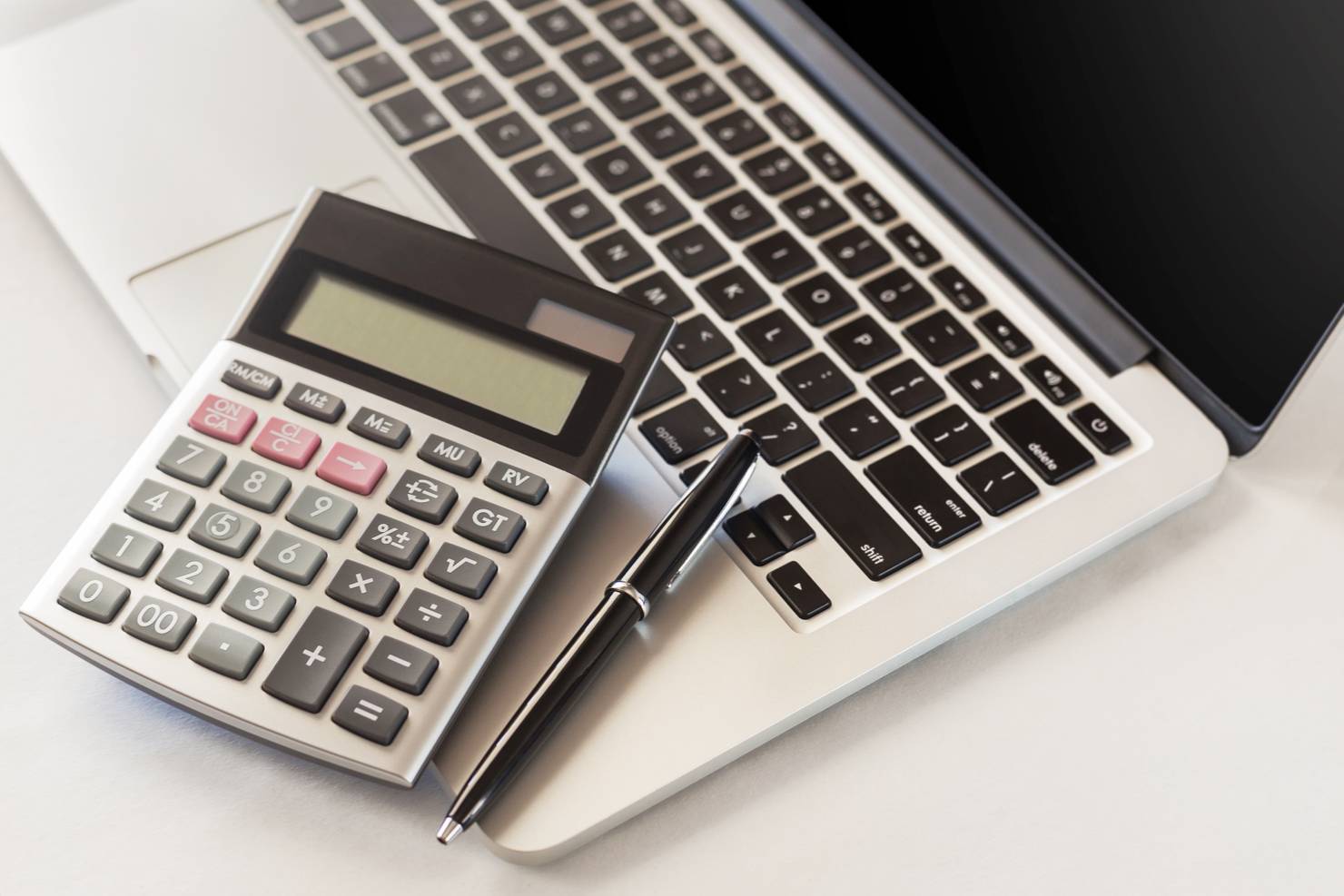 Calculator and laptop on a desk