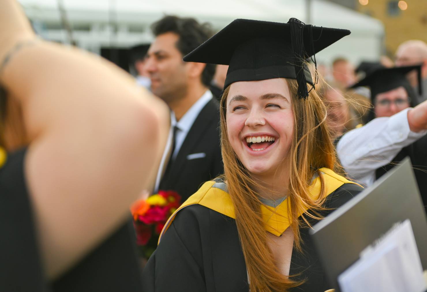 Close-up of a student smiling in their cap and gown