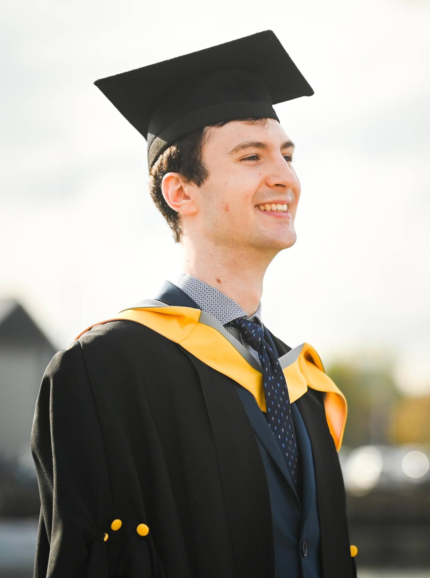 A student standing in their cap and gown