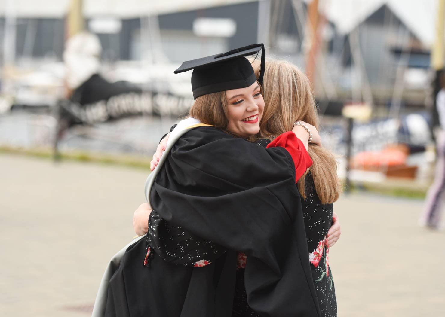 A student hugging their parent at graduation