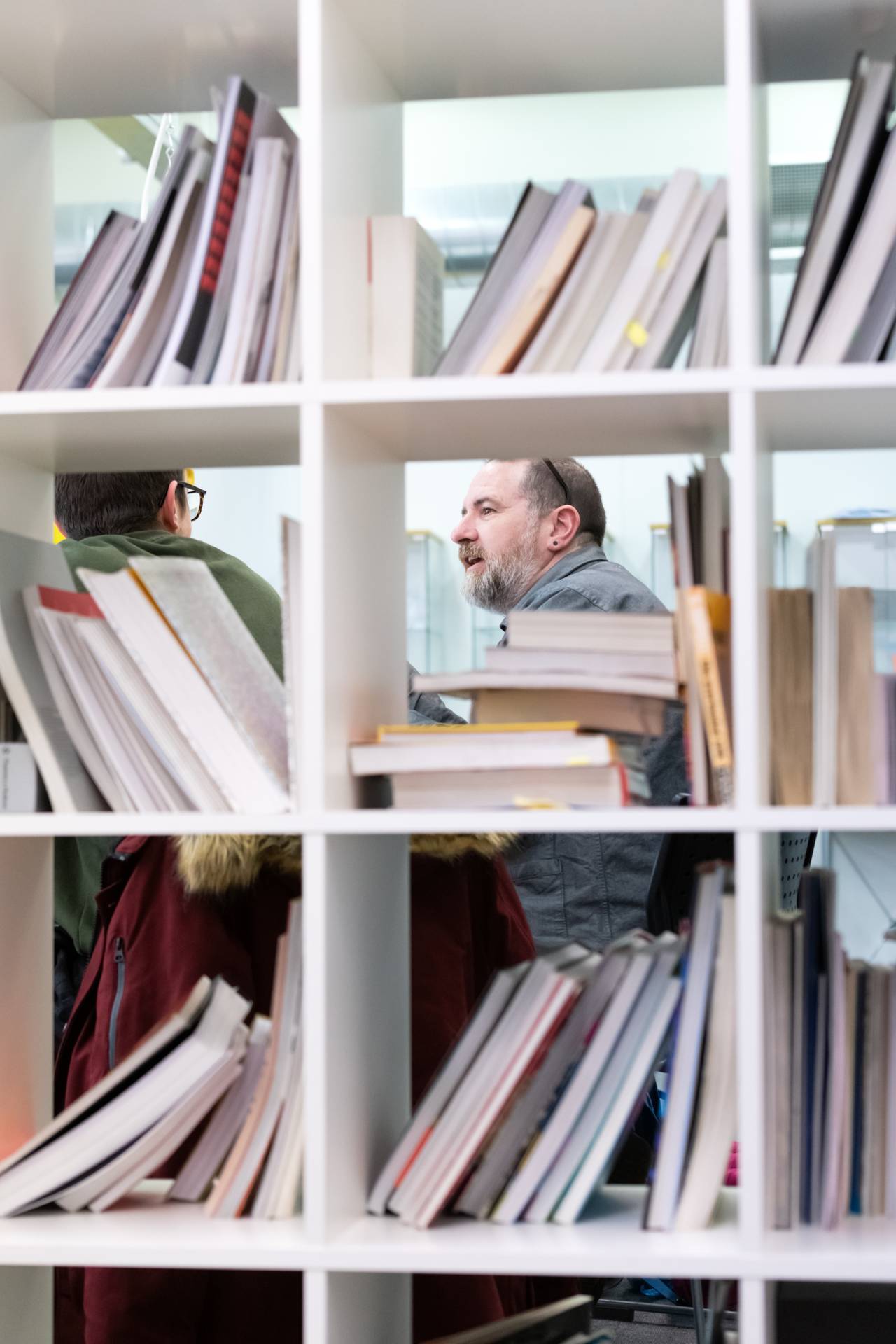 A view of a lecturer through a bookshelf