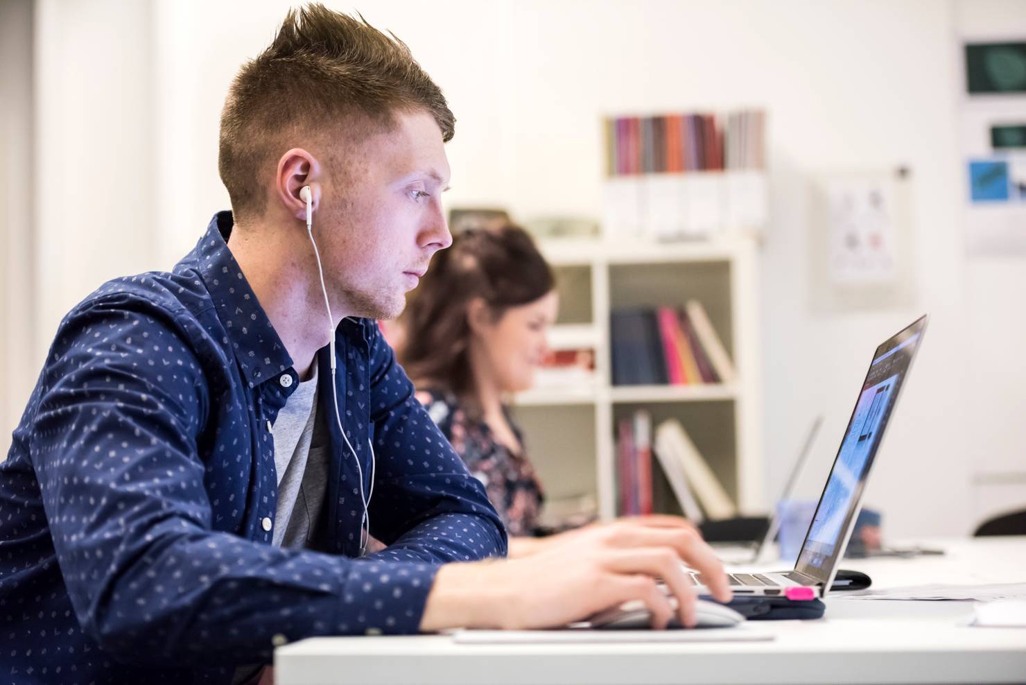 Two students sitting with laptops