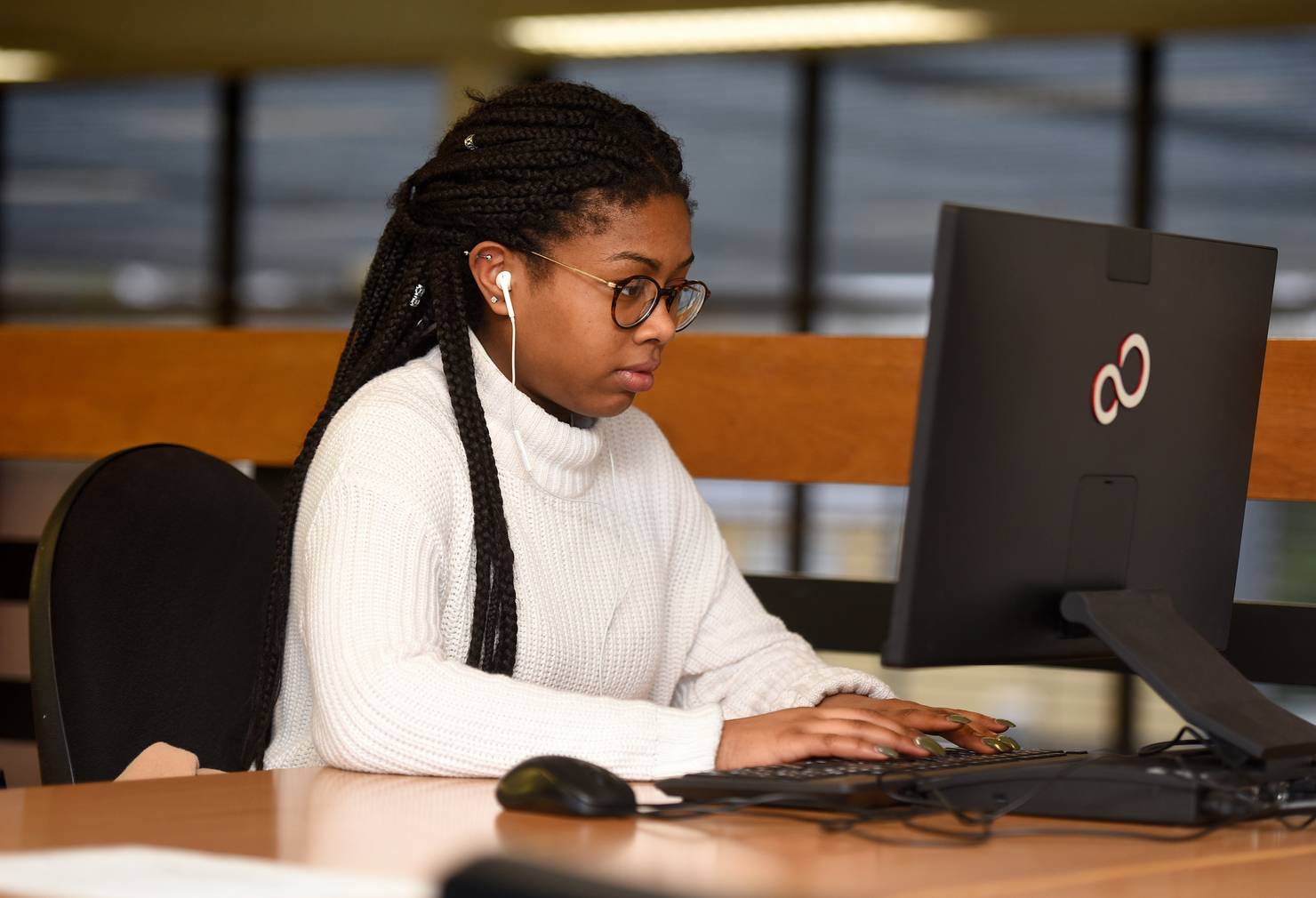 A student sitting at a computer in the library