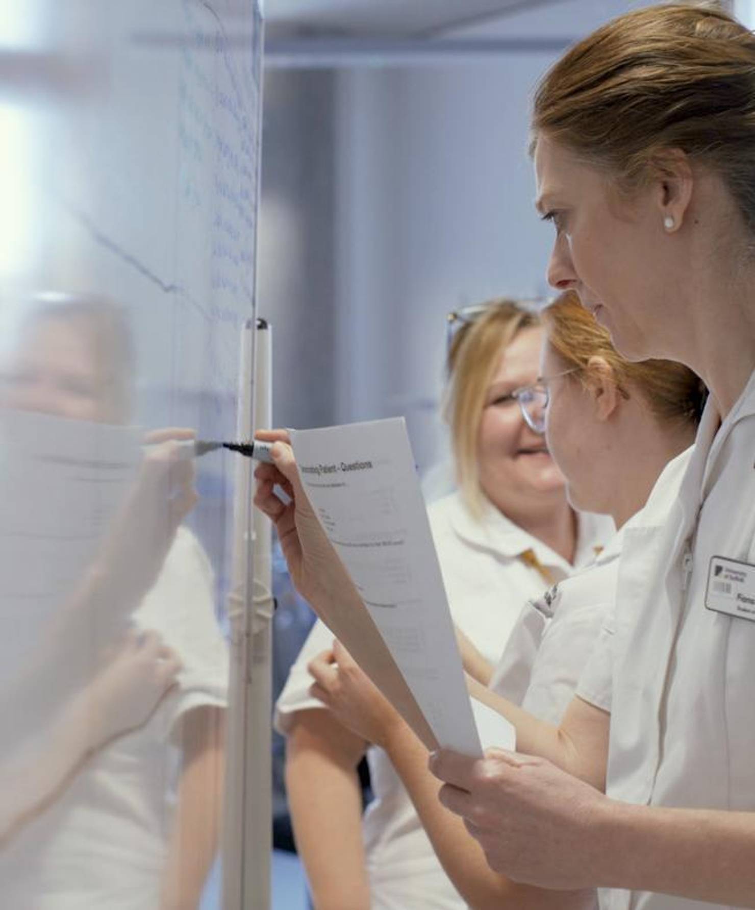 A student nurse writing on a whiteboard