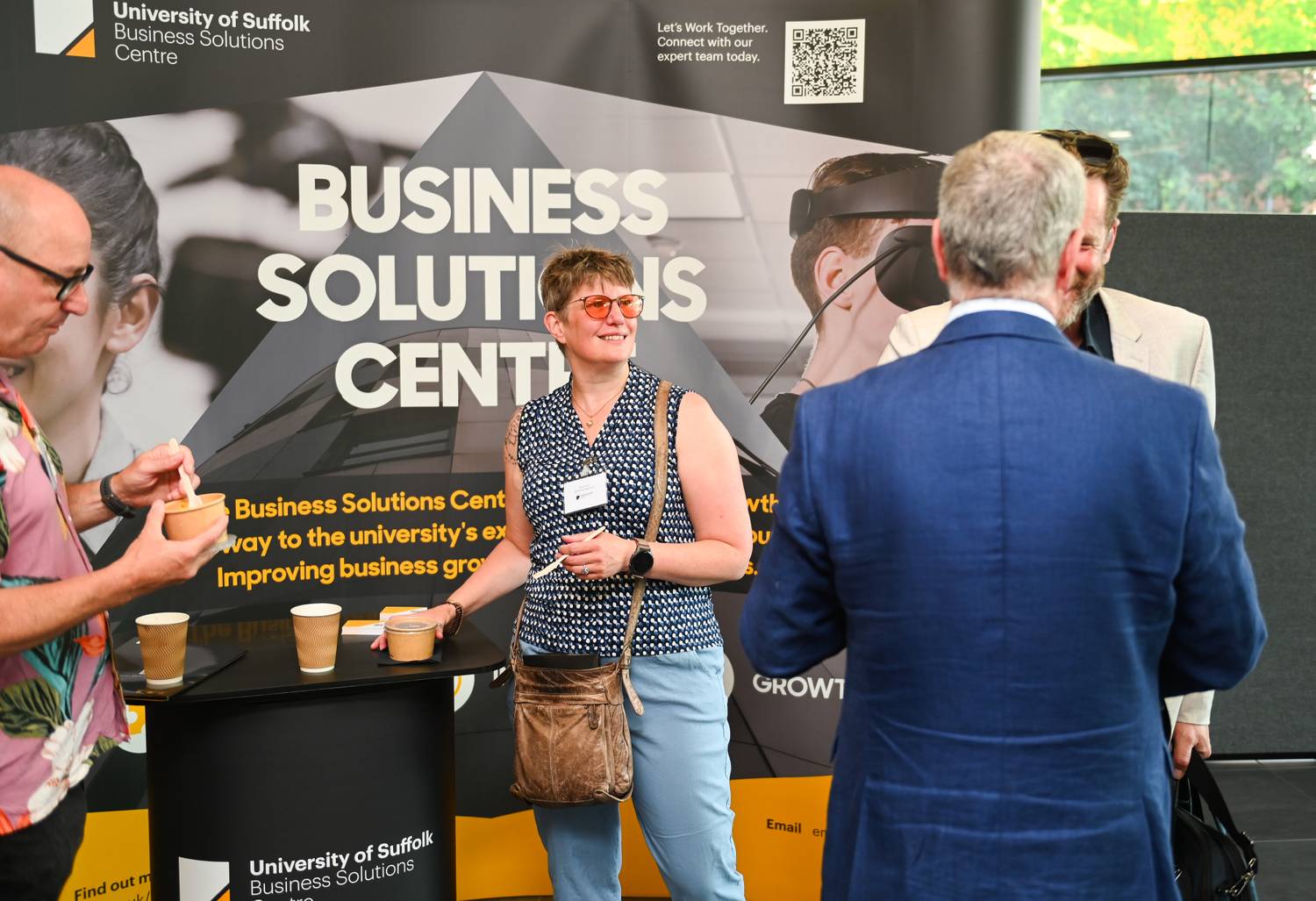 Attendees stood in front of a sign that says Business Solutions Centre