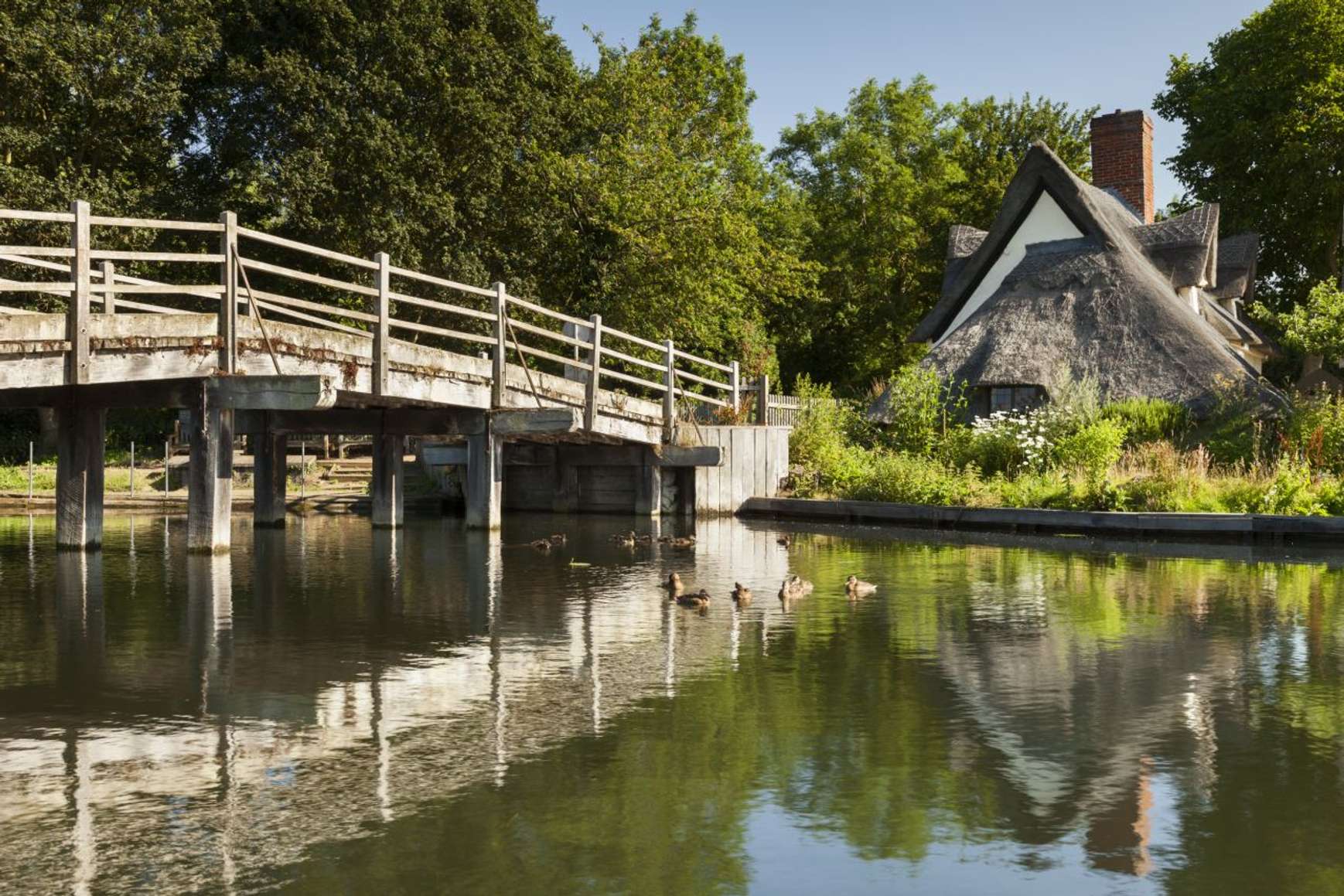 Bridge Cottage with the river and footbridge at Flatford. Image taken by Justin Minns