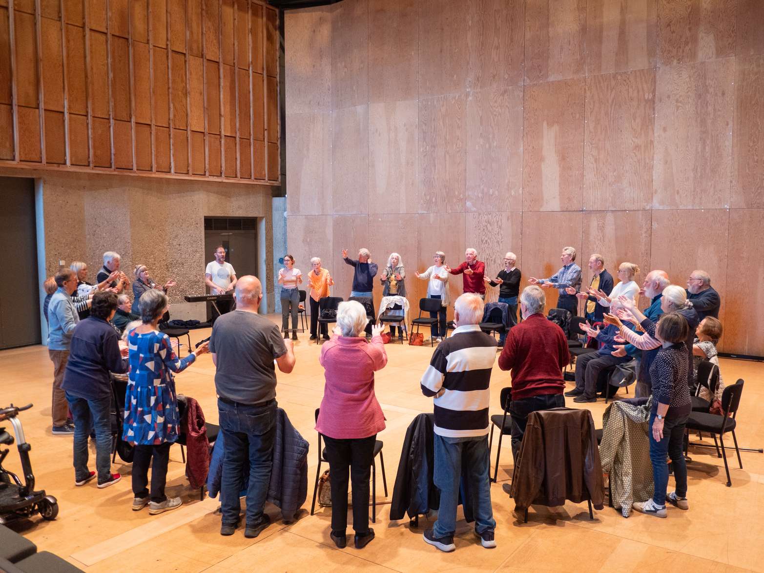 A group of participants with East Suffolk Skylarks gathered in a circle and singing