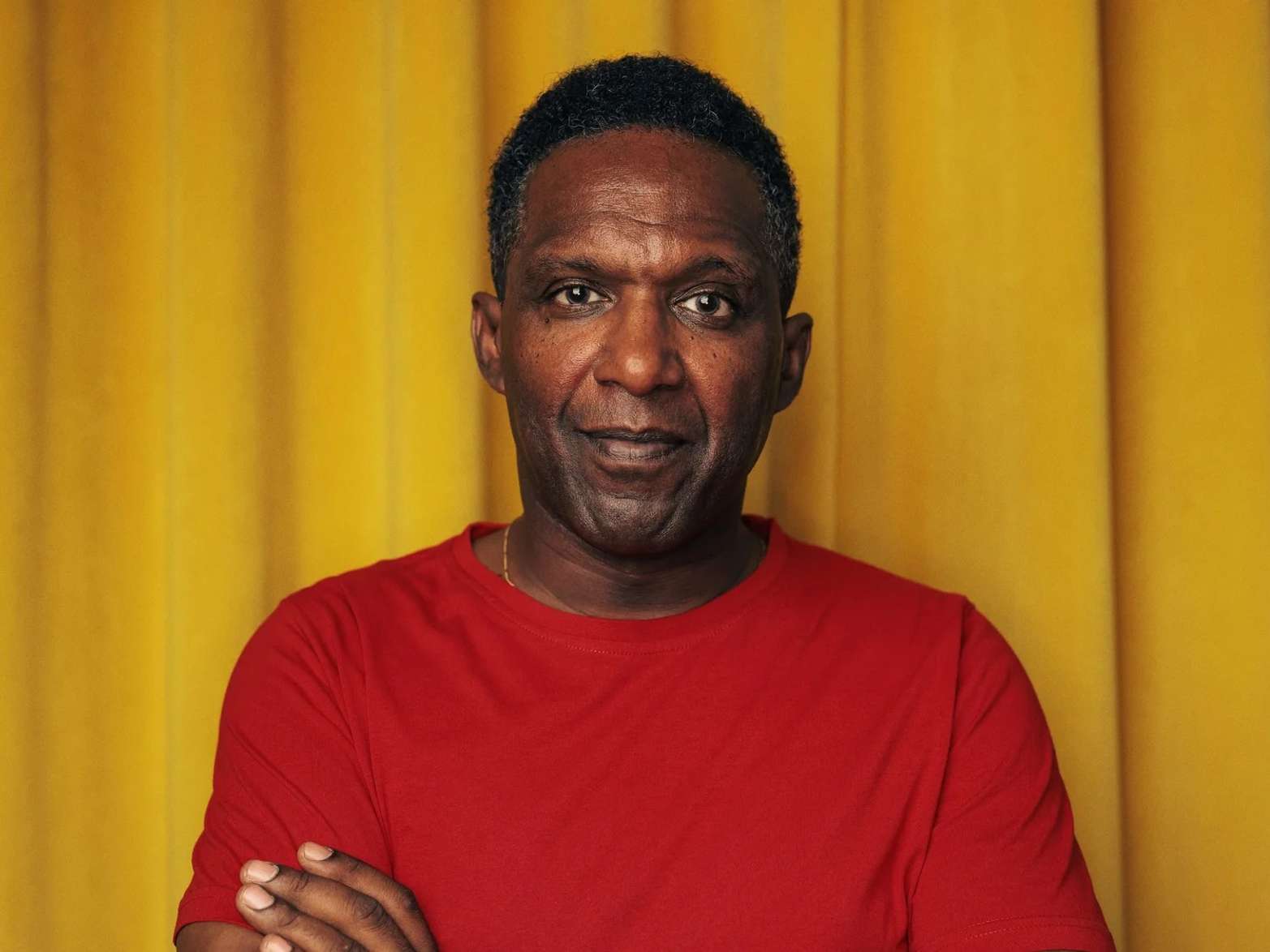 A head and shoulders photo of poet Lemn Sissay with his arms folded. Image credit: Ivan Weiss