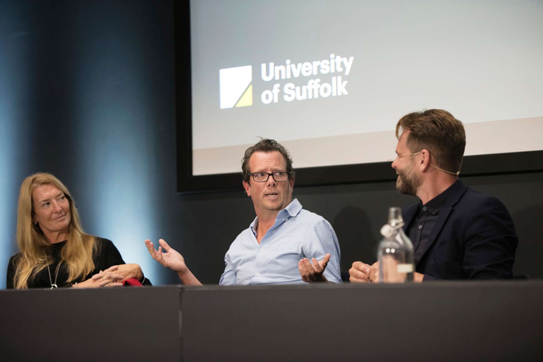 Panellists for the Spotlight Suffolk event speaking into microphones and seated behind a desk