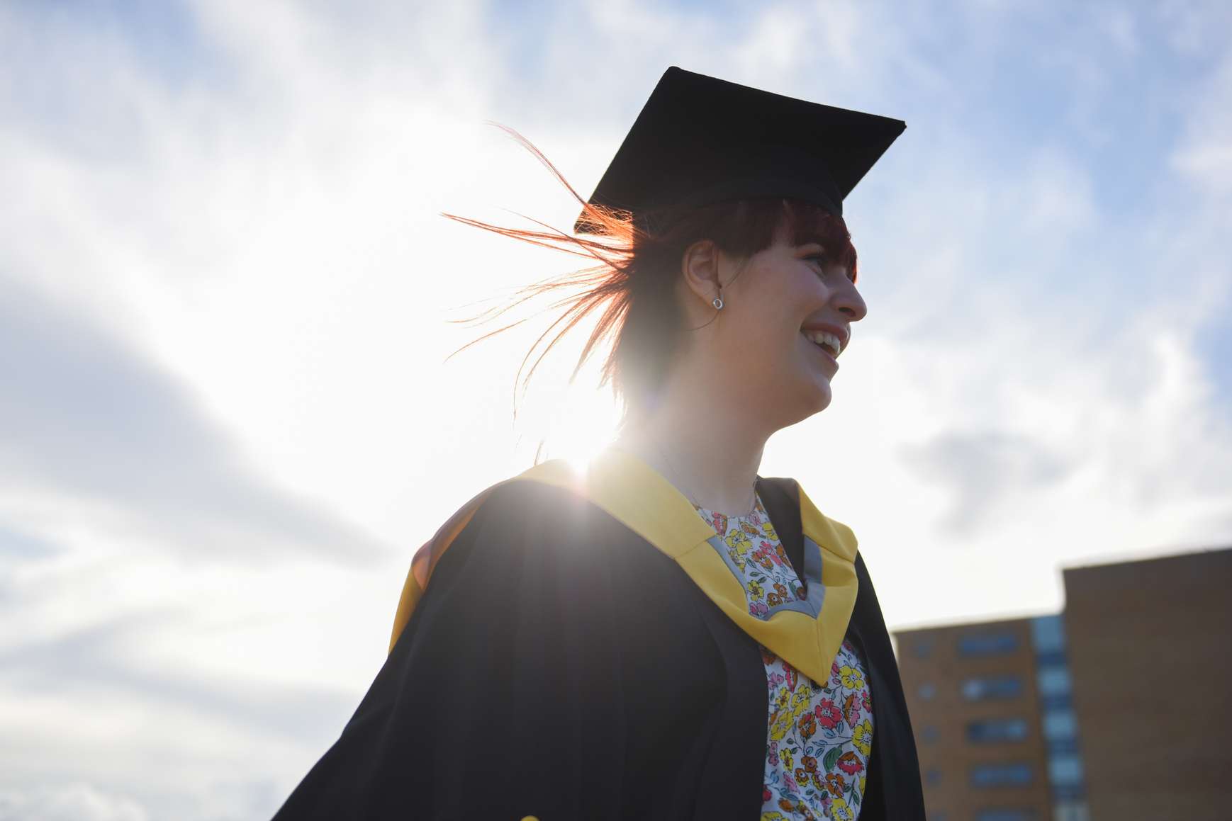 Close-up of student smiling in their cap and gown