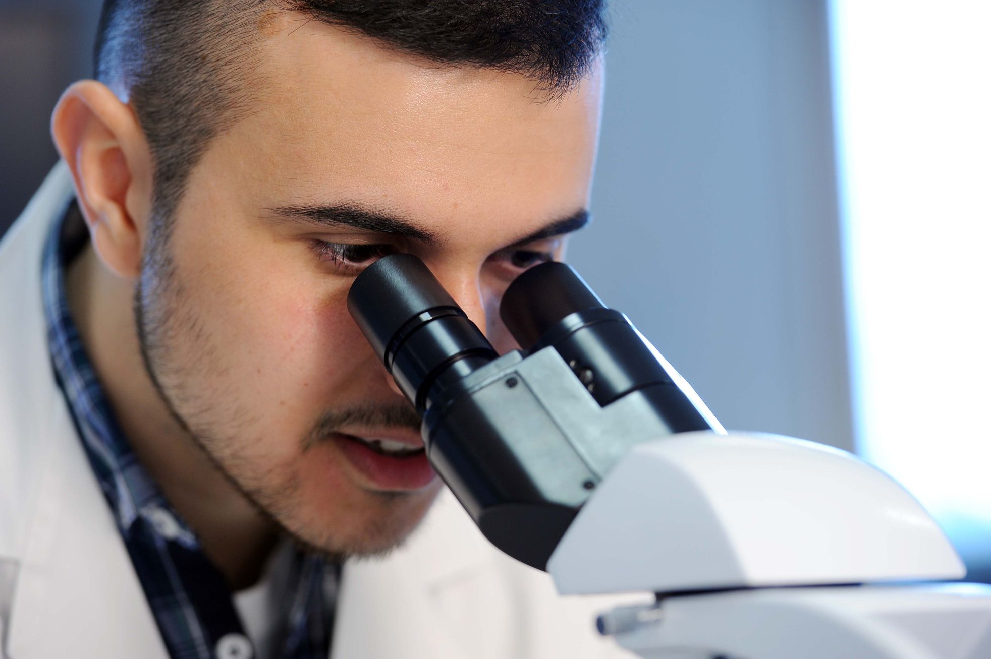 Close-up of a student looking through a microscope