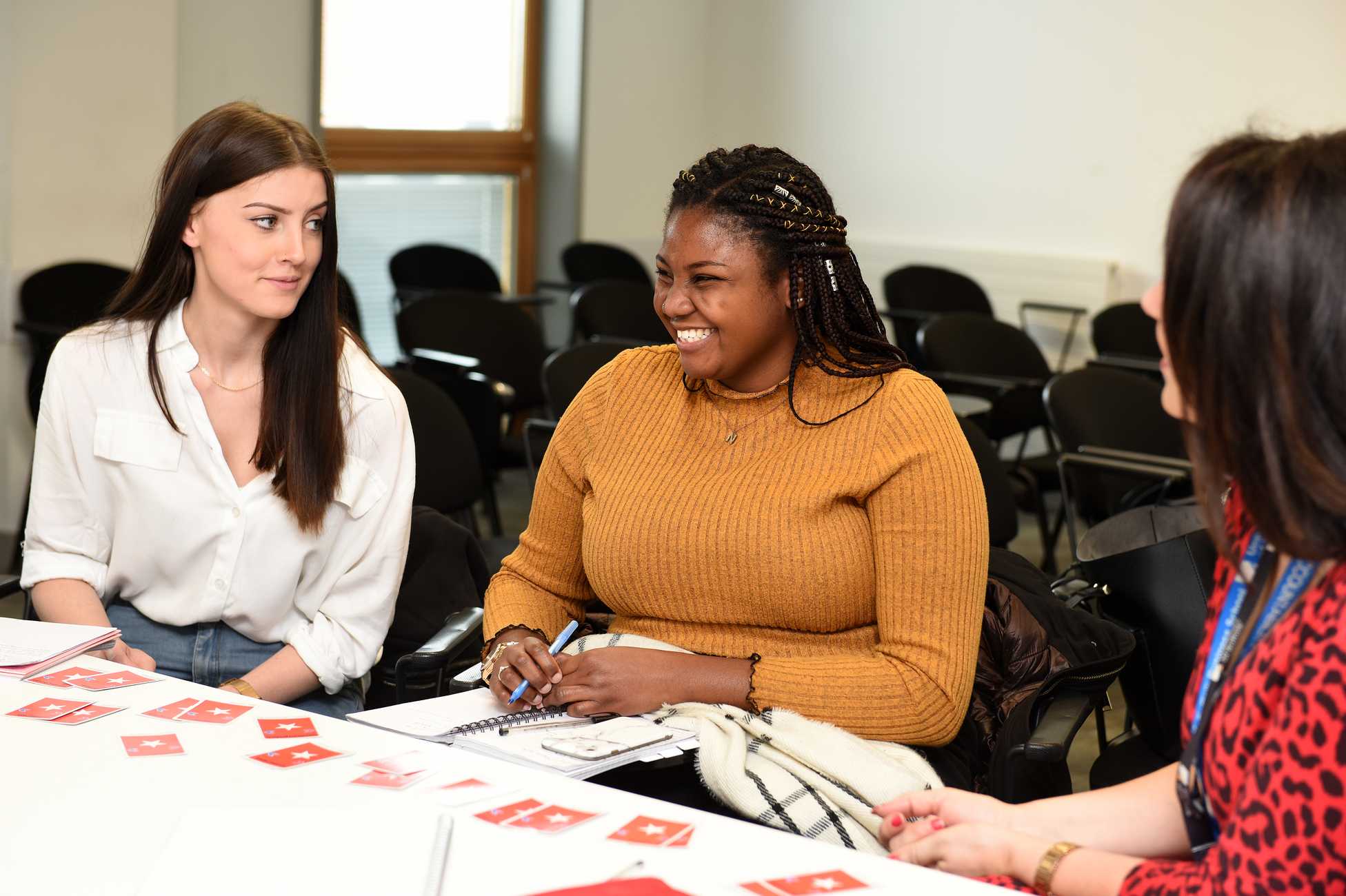 Two students sitting in a seminar with lecturer