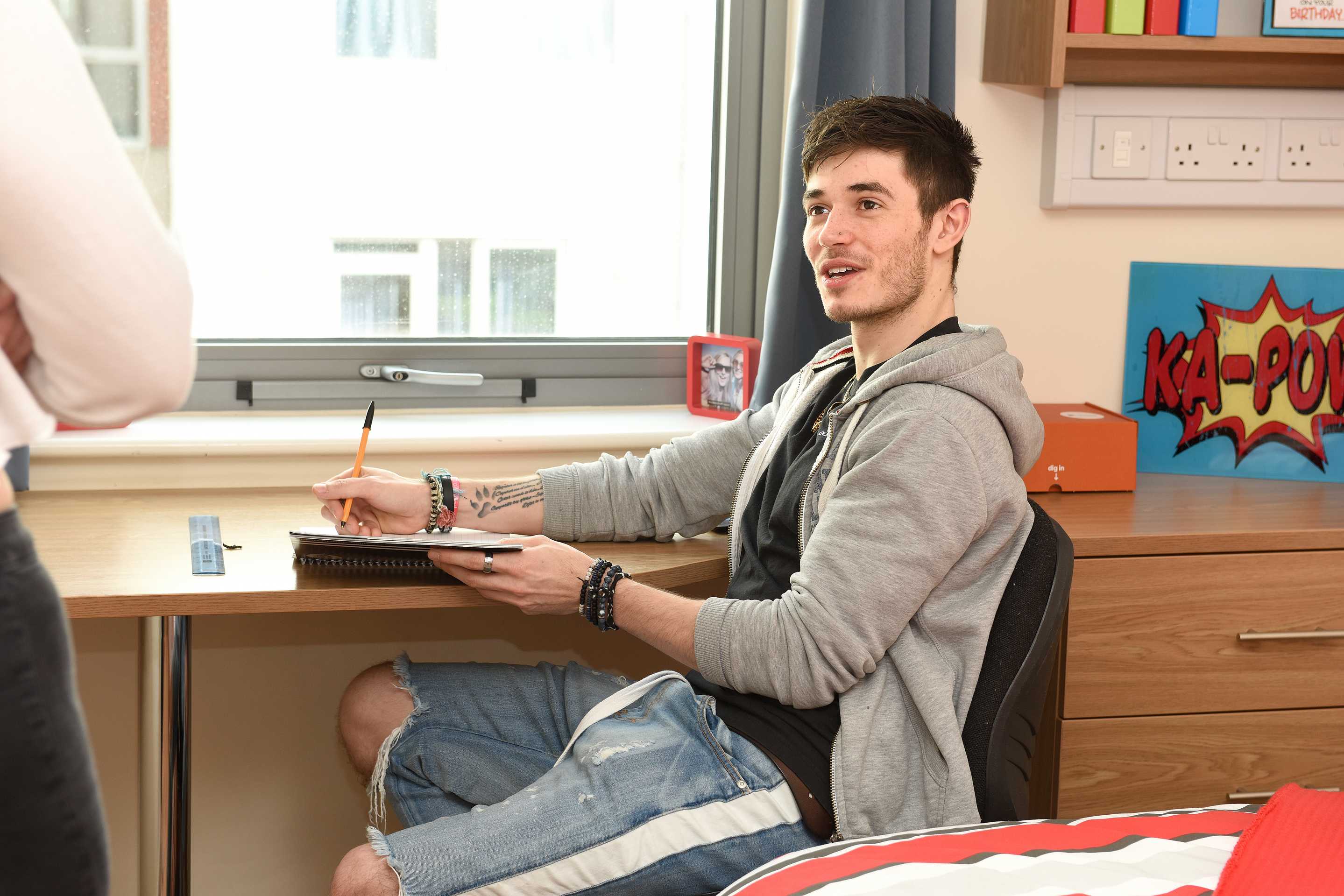 Student sitting at a desk in a bedroom