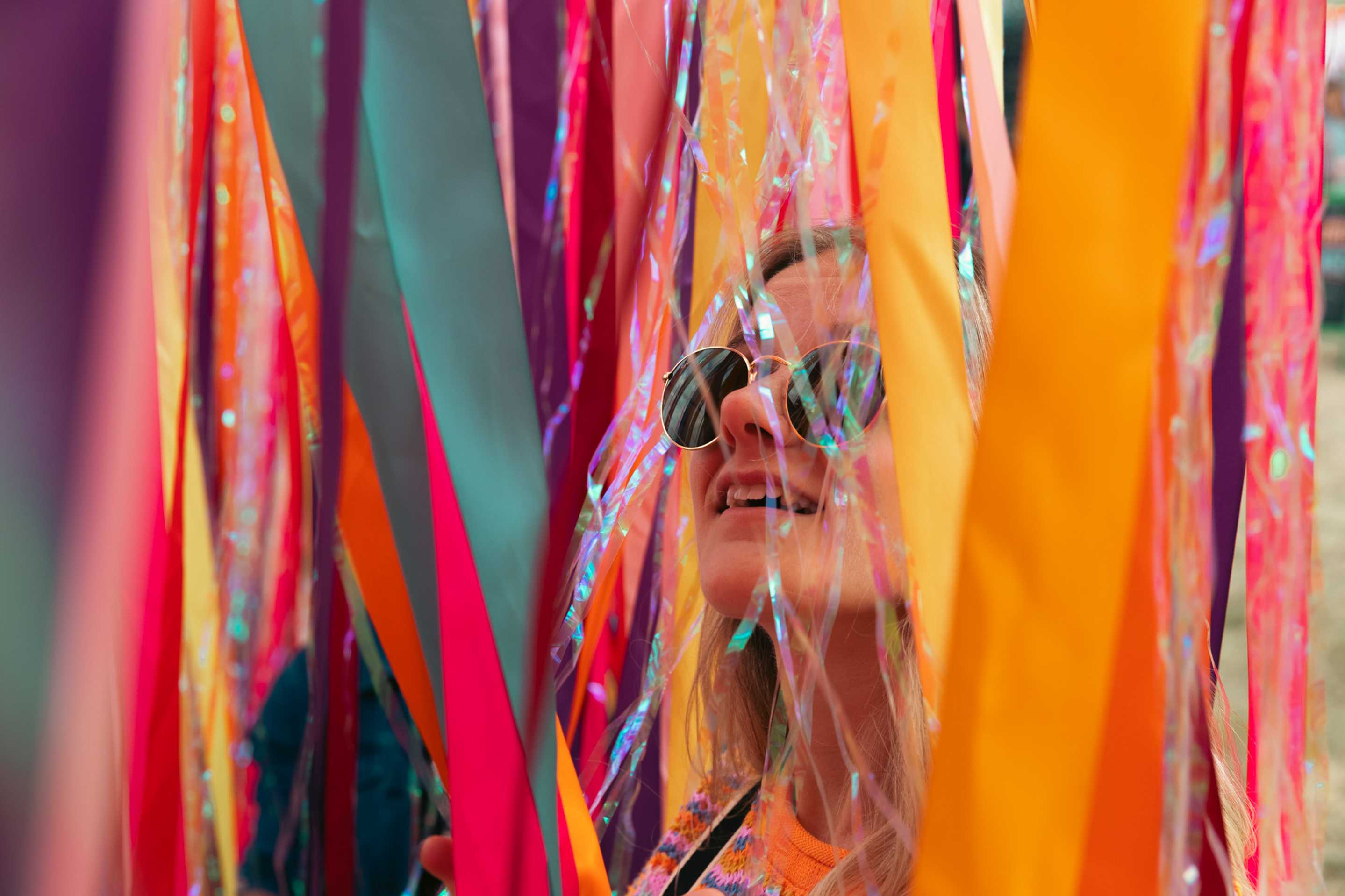 Student coming  through colourful streamers at the Latitude festival
