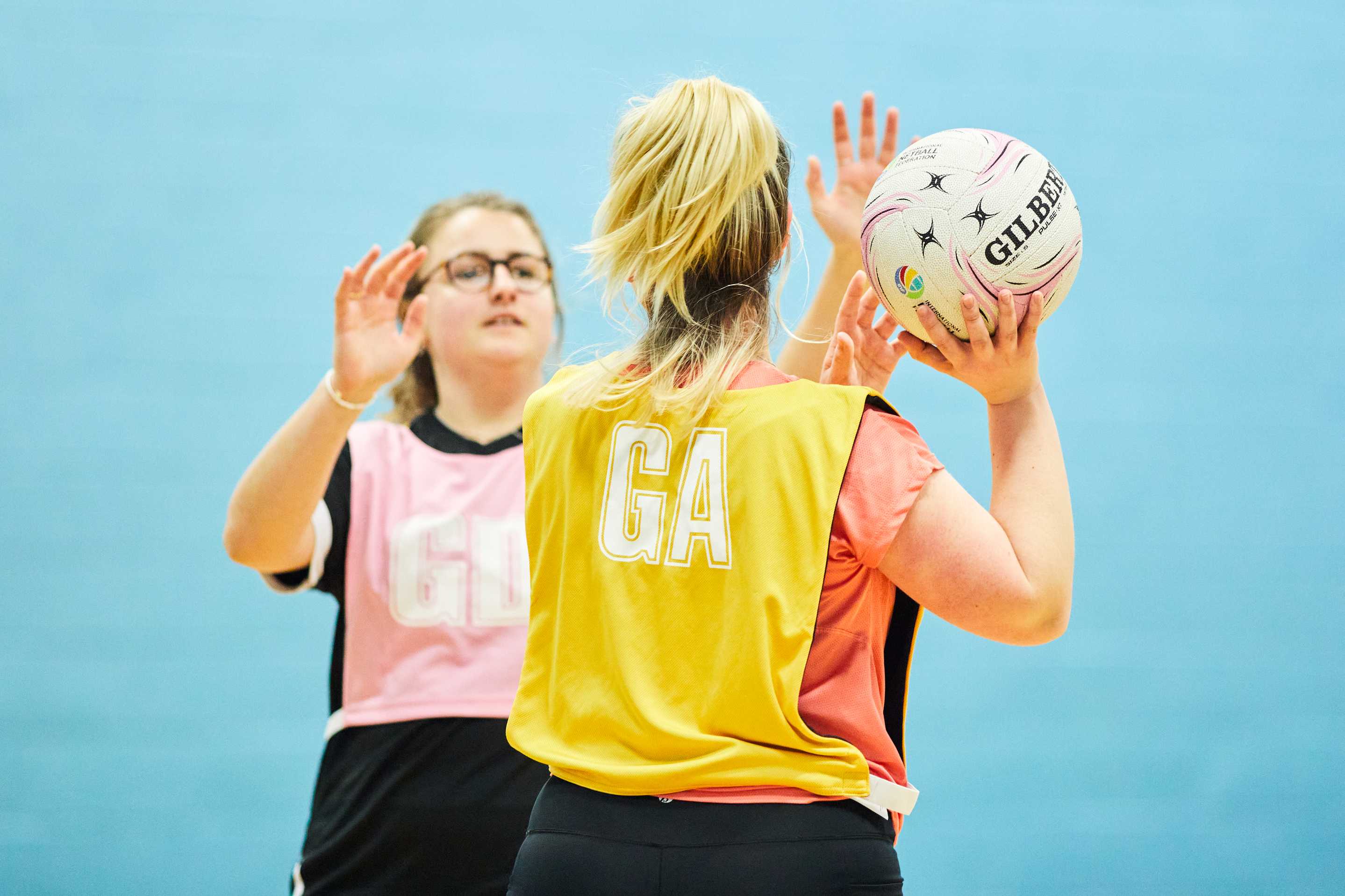Two students playing netball