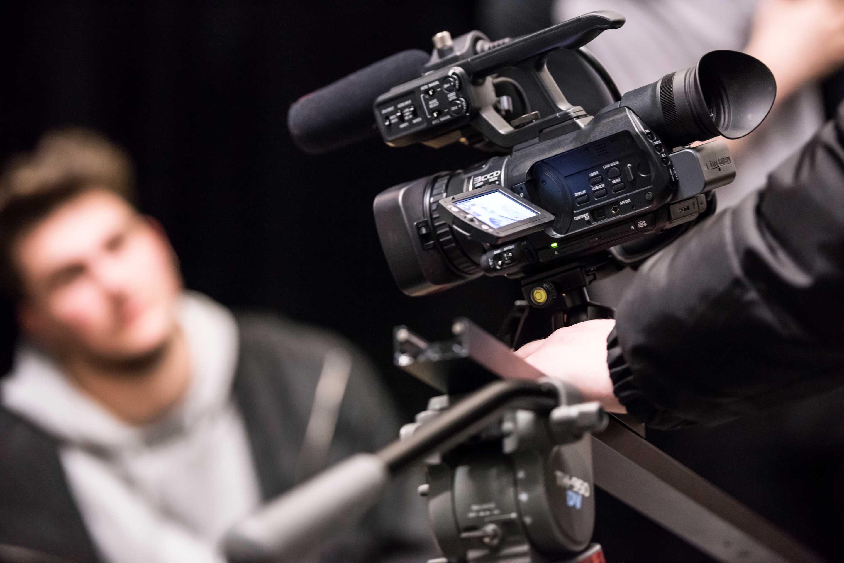 Close-up of a video camera filming a student