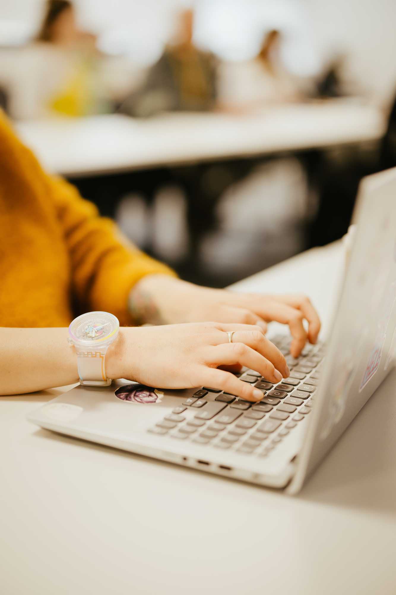 Close up of student typing at a laptop