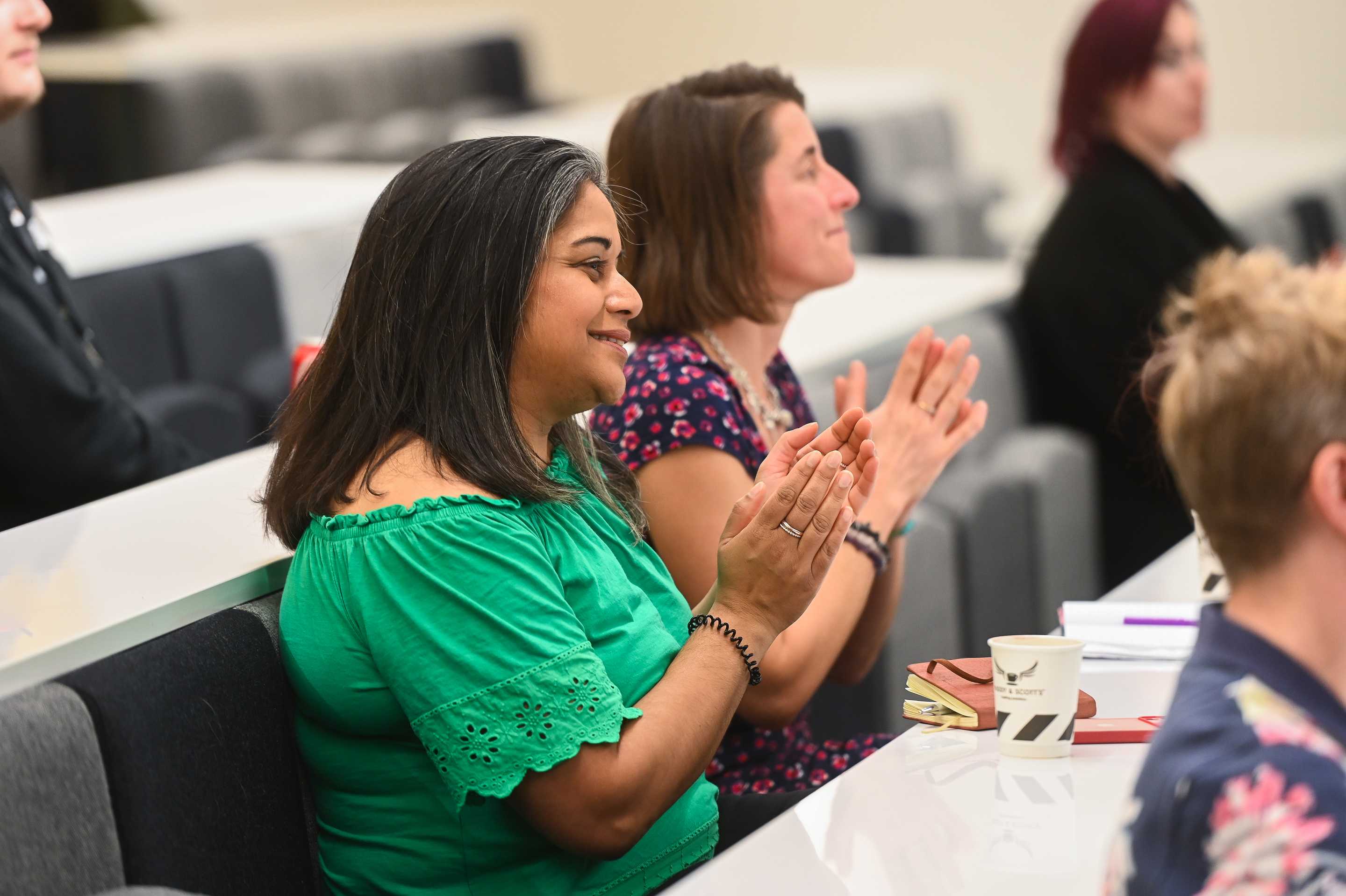 Two people sat in a lecture theatre