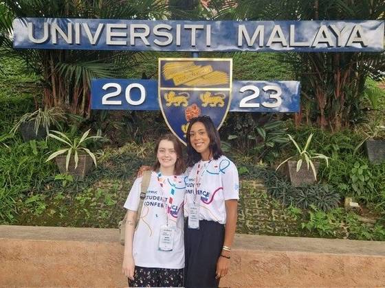 two students in front of a university sign