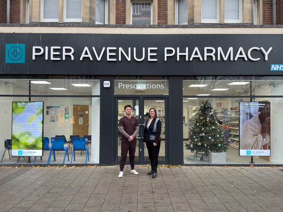 Junchao Jiang (left) from G.G. Graham and Dr Georgina Marsh (right) from the University of Suffolk standing outside a G.M. Graham pharmacy in Clacton