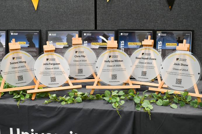 The six plaques honouring University of Suffolk alumni, displayed on a table