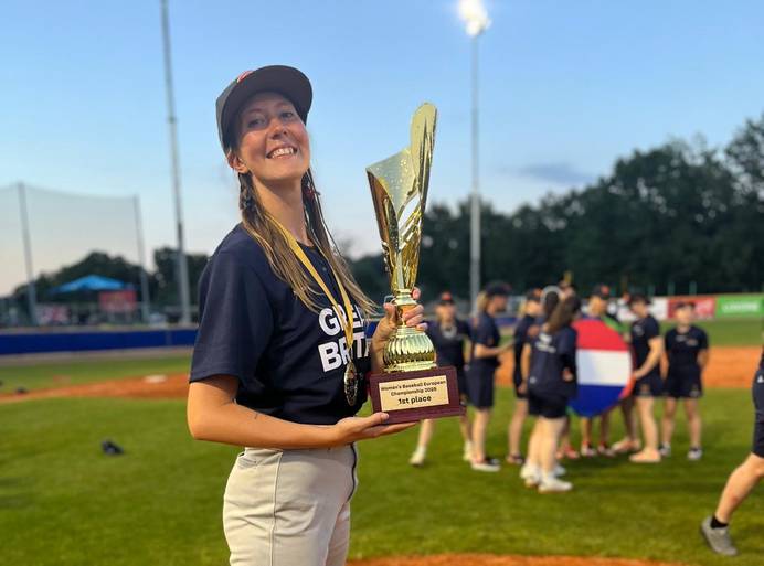 Oona holding the European championship trophy on the field, dressed in her team kit