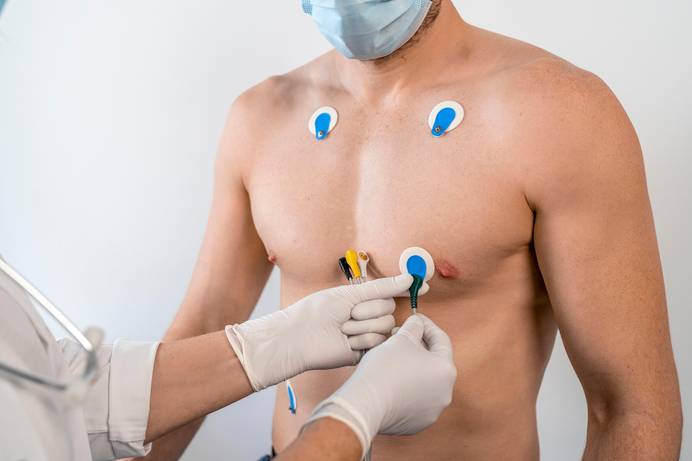 The chest and torso of a male patient with a healthcare worker attaching the Cardisio wire pads to the patient's body. Photo credit: Cardisio GmbH