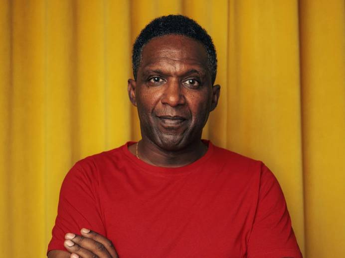 A head and shoulders photo of poet Lemn Sissay with his arms folded. Image credit: Ivan Weiss