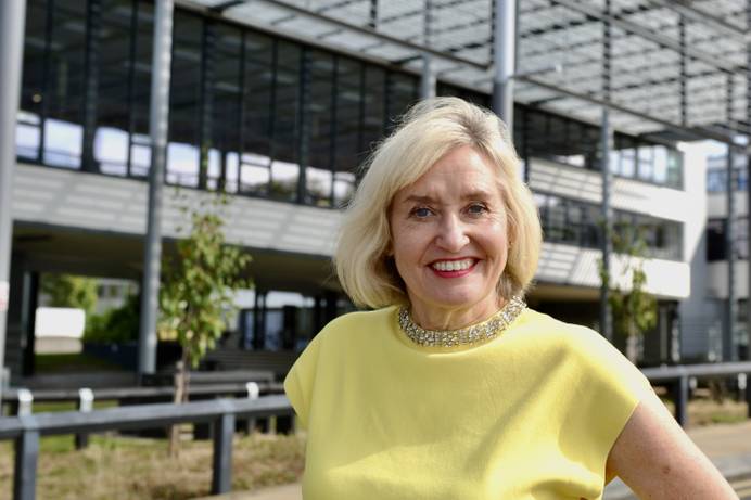 New Vice-Chancellor Jenny Higham, standing in front of the Library Building and smiling