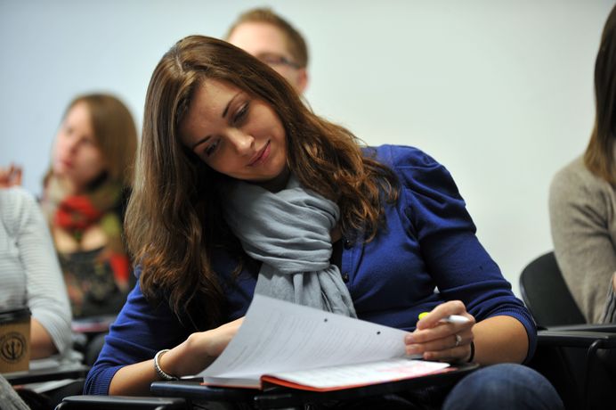 Close-up of student sitting and reading in a lecture