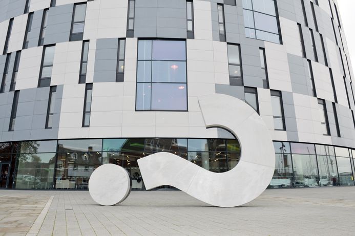 University campus building and question mark sculpture