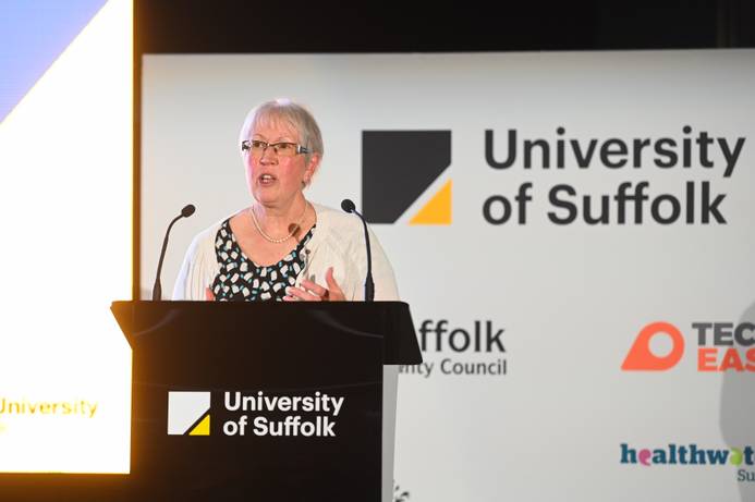 Prof Helen Langton standing at a lectern addressing the audience for the Civic University event