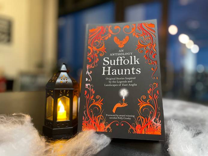 The Suffolk Haunts book propped up with a small lantern beside it