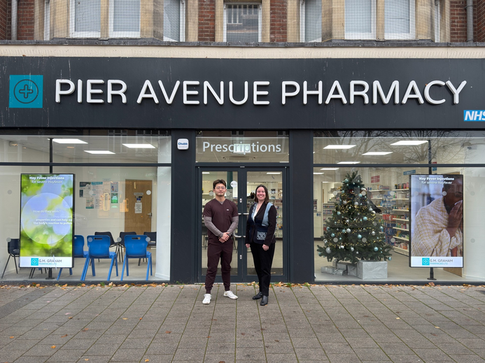 Junchao Jiang (left) from G.G. Graham and Dr Georgina Marsh (right) from the University of Suffolk standing outside a G.M. Graham pharmacy in Clacton