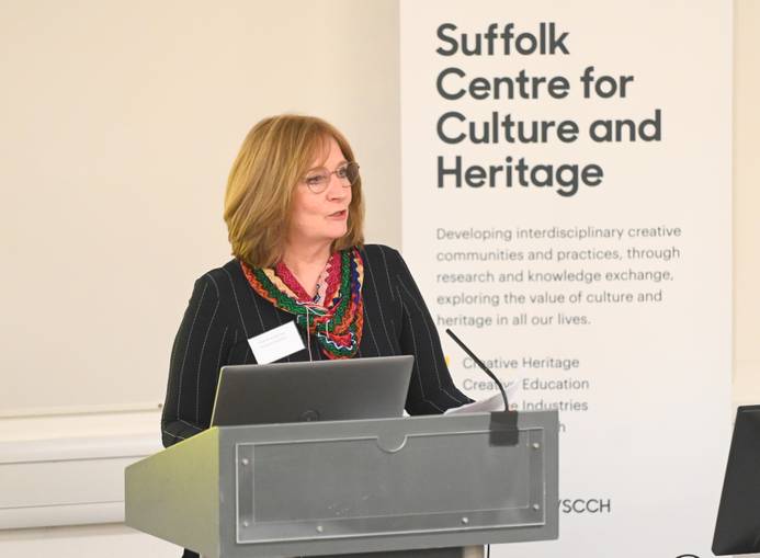 Dr Amanda Hodgkinson standing at a lectern and addressing the audience at the launch of the new Suffolk Centre for Culture and Heritage. behind her is a banner which says 'Suffolk Centre for Culture and Heritage'