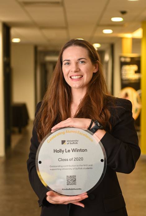 Graduate holding a plaque