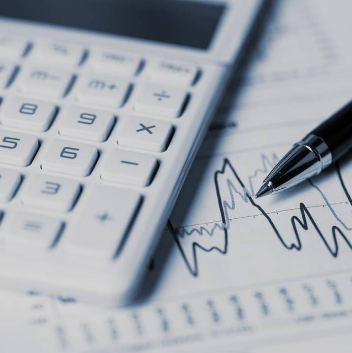 Close-up of calculator, pen and charts