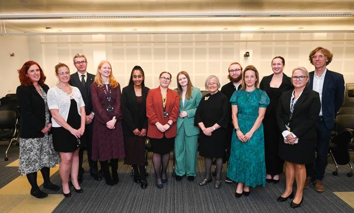 A group photo of Lady Hale with students and staff standing in the lecture theatre