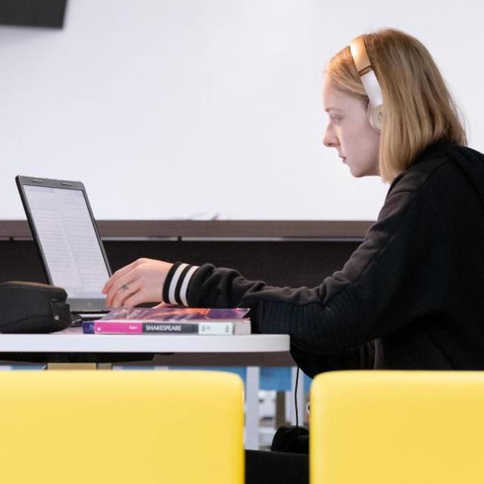 A student sitting with a laptop