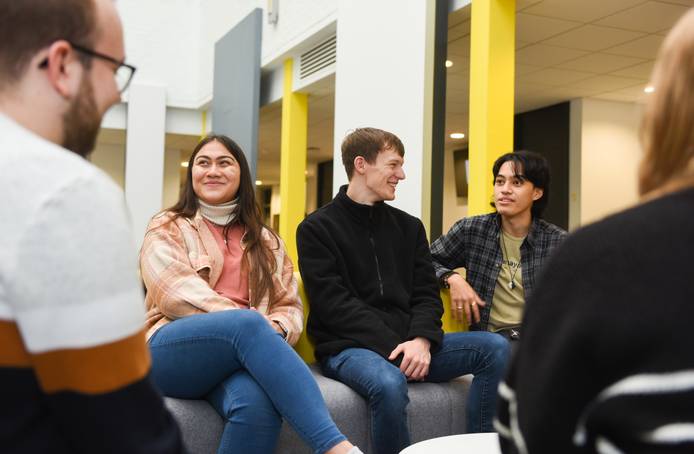 Group of students sitting and talking in The Atrium foyer