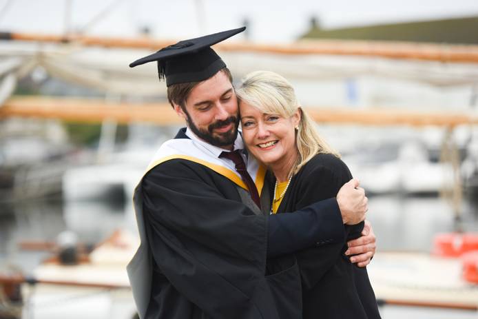 A student hugging their parent at graduation