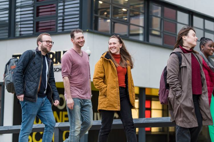 Group of student walk past The Atrium