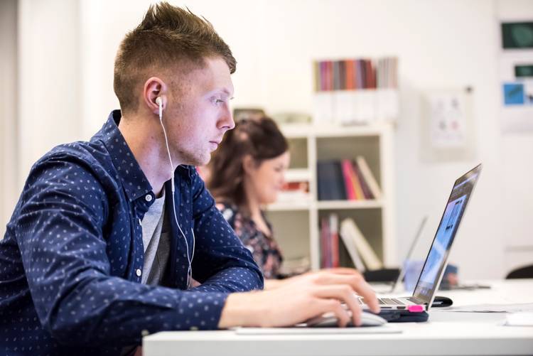 Two students sitting with laptops