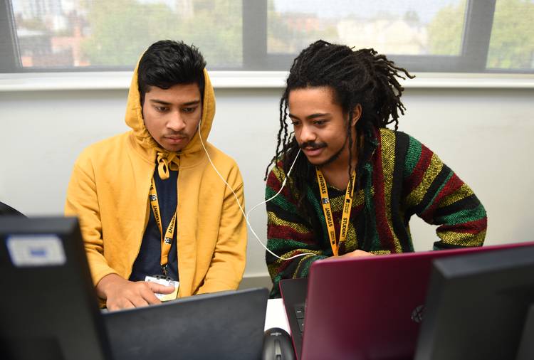 Two students sitting and computers