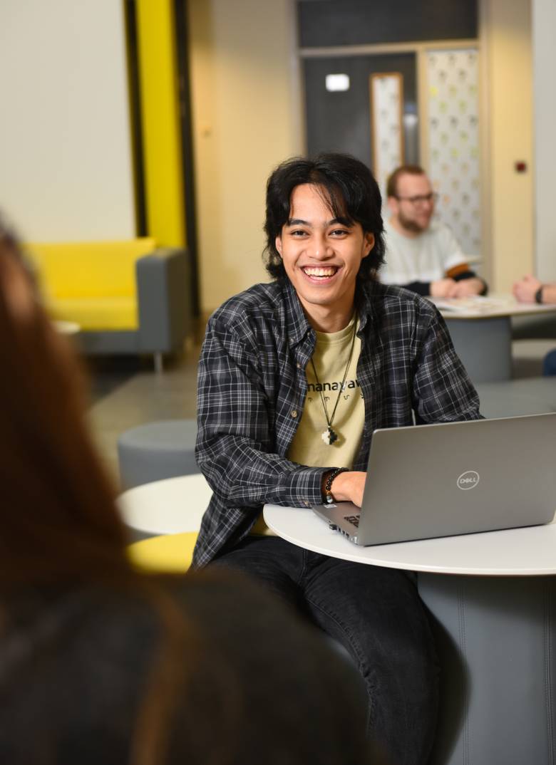 A student sitting with a laptop