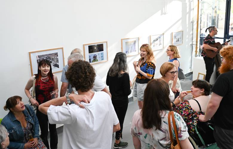A group of students gathered with guests at the Arts Degree Show