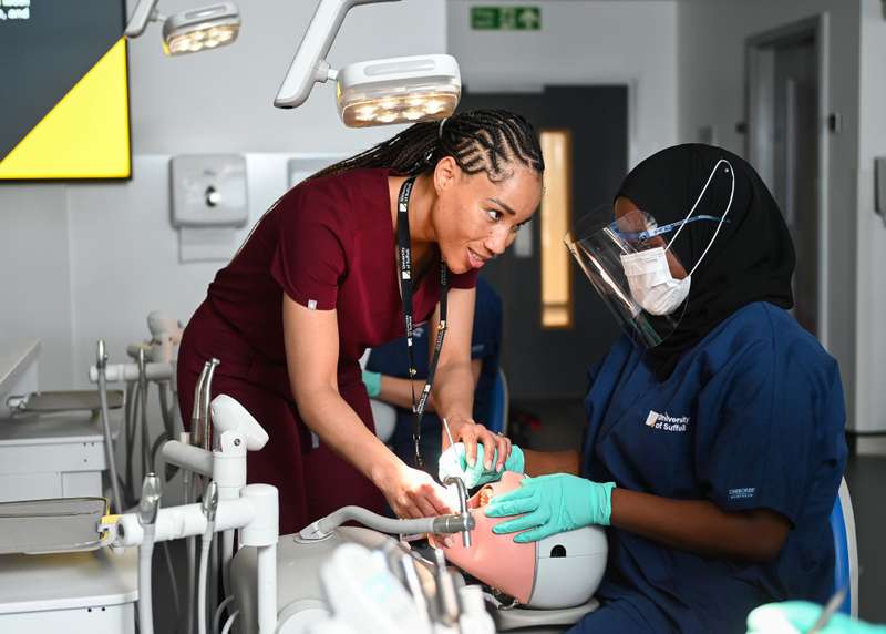 Dental student and lecturer in lab